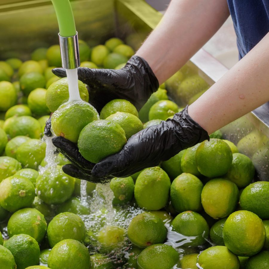Worker,Washing,Fresh,Limes,In,A,Commercial,Kitchen,For,Food